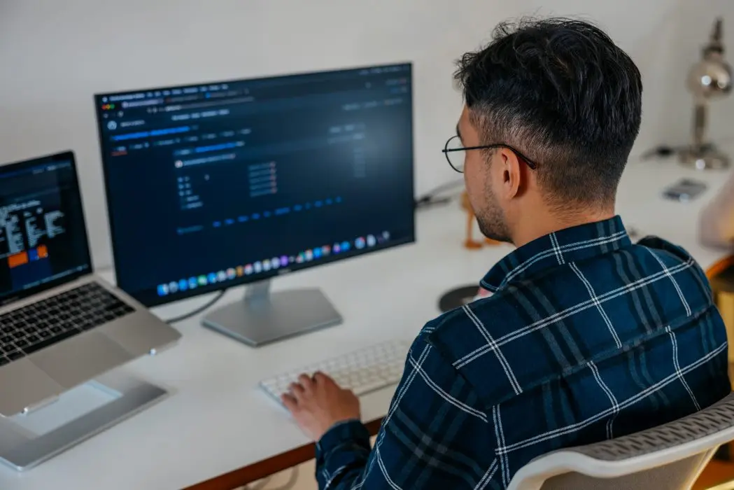 A developer reviewing code on a large monitor